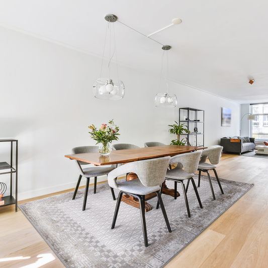 Modern open concept home with minimalist dining area, featuring dark wooden table and grey chairs on Geometric Beige Rug