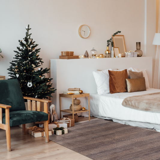Mystic Stripes Rug in a cozy Scandinavian bedroom with Christmas tree, green velvet chair, brown and beige pillow, and Christmas decorations