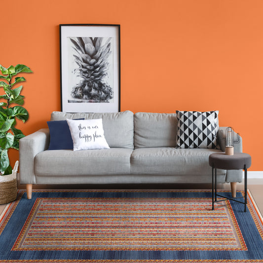 Cozy modern living room with Mystic Bogo Rug, grey sofa in front of orange wall, coffee table and plant in a basket