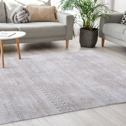 Tribal Ivory Rug in a bright Scandinavian living room along with minimalist grey sofas, modern white coffee table, pillows and plant